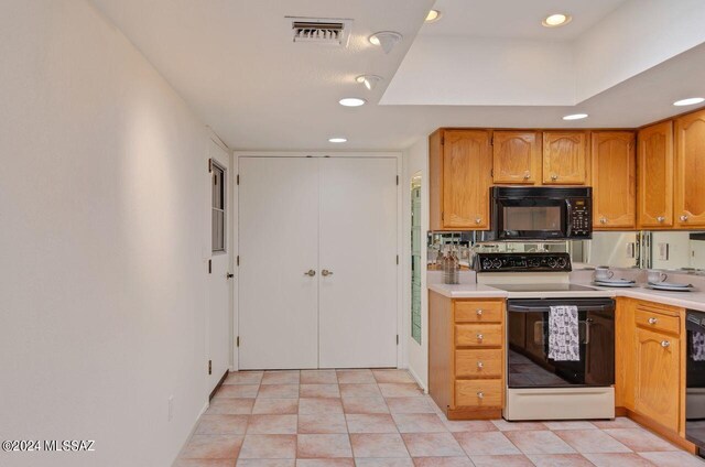 kitchen with dishwashing machine, light tile patterned flooring, and electric range