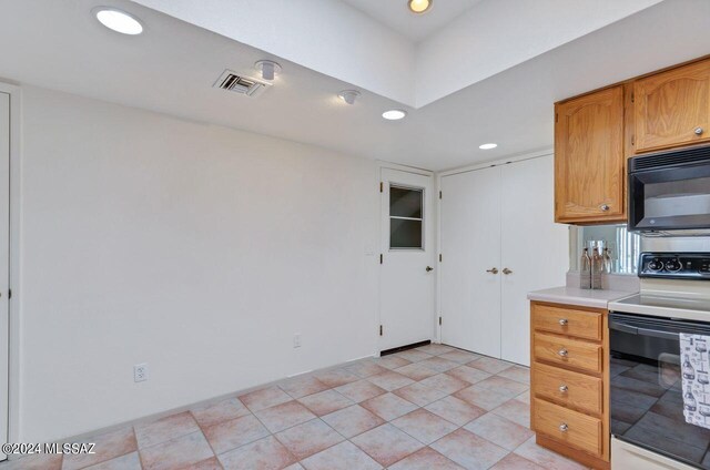 kitchen featuring light tile patterned flooring and range with electric cooktop