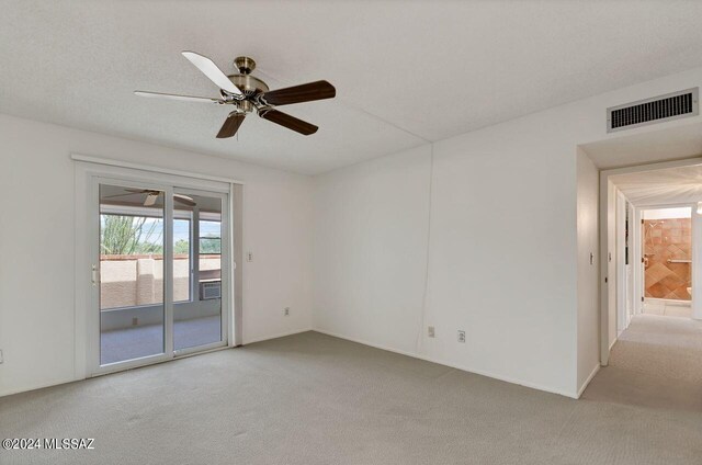 unfurnished bedroom with ceiling fan, light carpet, access to outside, and a textured ceiling