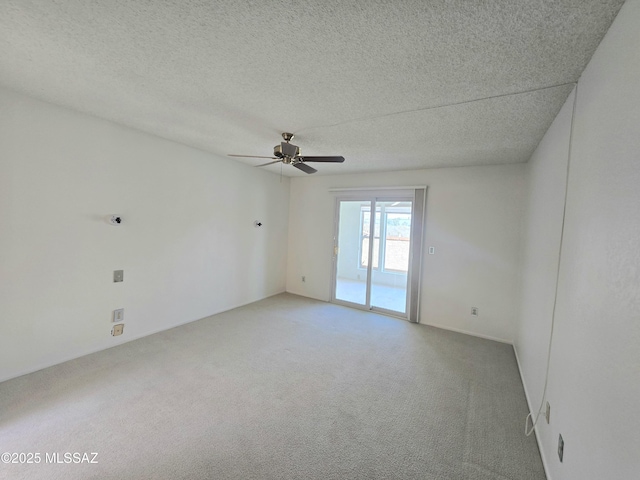 empty room with light carpet, a ceiling fan, and a textured ceiling