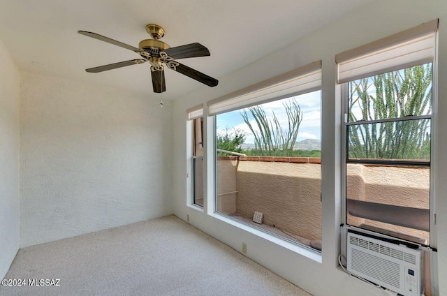 unfurnished room with a textured wall, carpet flooring, cooling unit, and a wealth of natural light