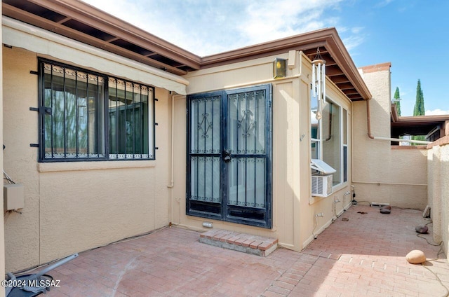 property entrance with a patio and stucco siding