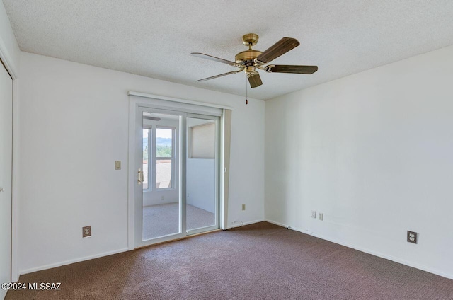 spare room featuring dark carpet, a textured ceiling, baseboards, and ceiling fan