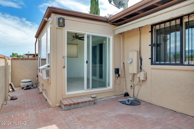 entrance to property featuring ceiling fan and a patio