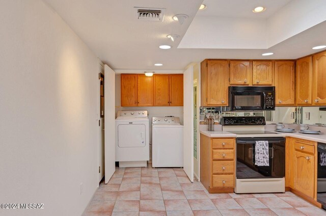 kitchen featuring black dishwasher, light tile patterned floors, a skylight, stainless steel refrigerator, and ceiling fan