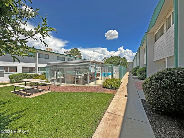 view of community with a yard and a pool