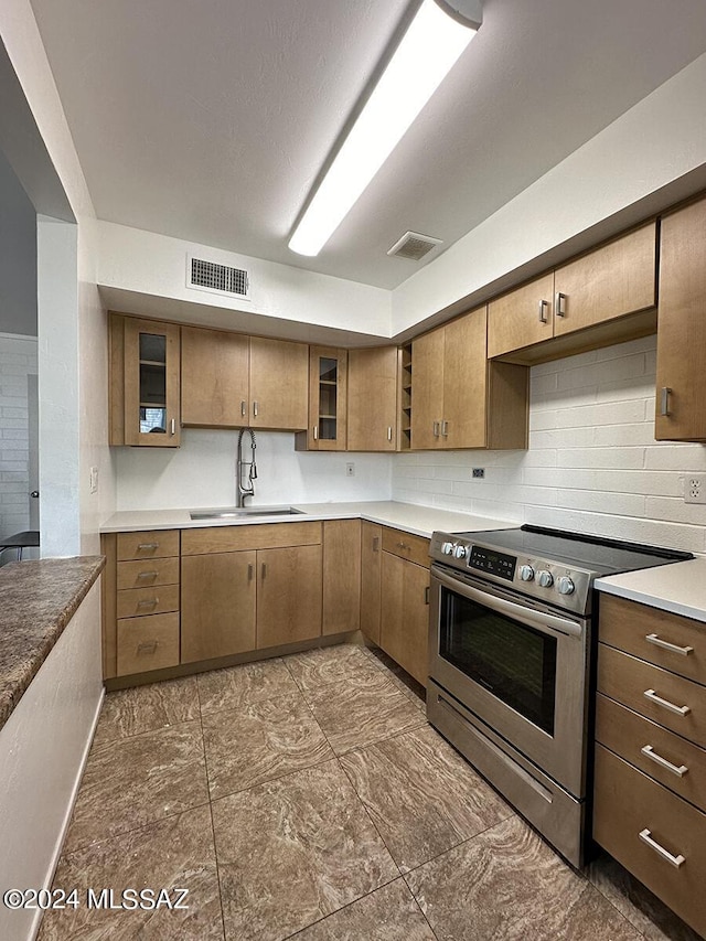 kitchen featuring sink, electric range, and tasteful backsplash