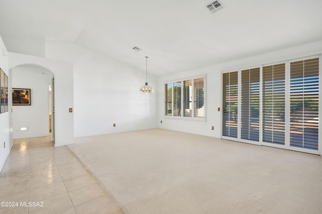 unfurnished room featuring light tile patterned floors, visible vents, arched walkways, light colored carpet, and lofted ceiling