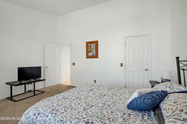 bedroom with carpet floors and a high ceiling