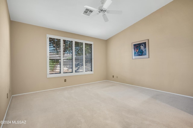 unfurnished room with light colored carpet, visible vents, a ceiling fan, vaulted ceiling, and baseboards