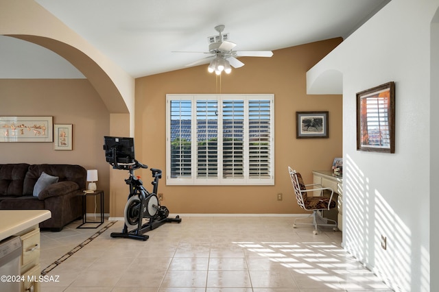 exercise area featuring vaulted ceiling, ceiling fan, light tile patterned floors, and baseboards