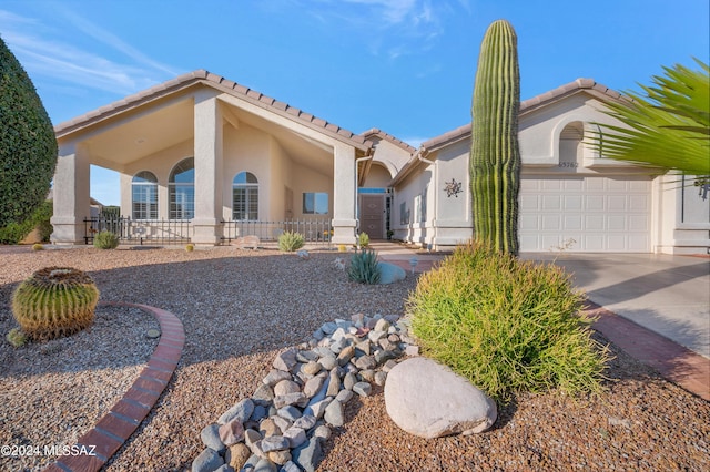 mediterranean / spanish house featuring a garage, concrete driveway, and stucco siding