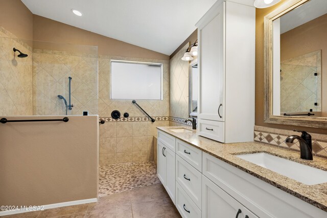 kitchen featuring appliances with stainless steel finishes, light brown cabinets, light tile patterned floors, lofted ceiling, and sink