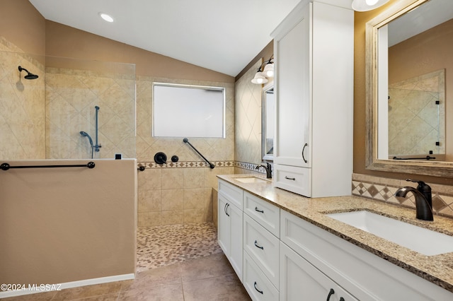 full bath with double vanity, vaulted ceiling, a sink, and a walk in shower