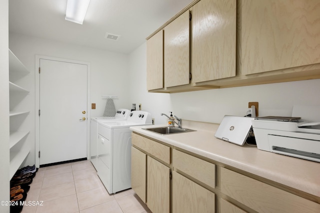 washroom featuring light tile patterned floors, a sink, visible vents, independent washer and dryer, and cabinet space