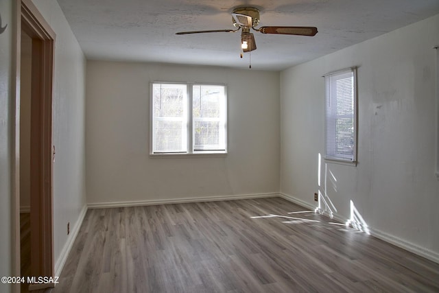 empty room featuring a textured ceiling, light hardwood / wood-style floors, and ceiling fan