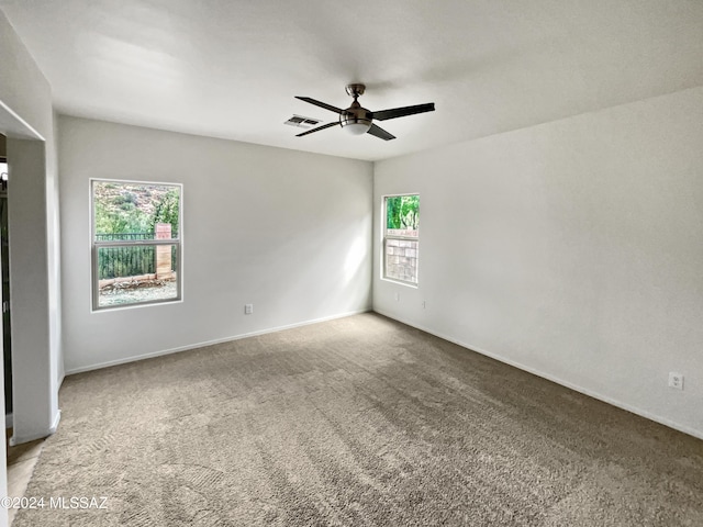 empty room with ceiling fan and carpet floors