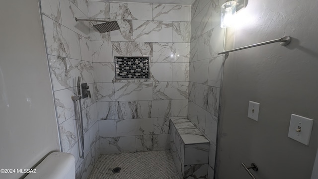 bathroom featuring a tile shower and toilet