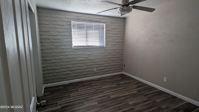 empty room with ceiling fan, dark hardwood / wood-style floors, and a textured ceiling