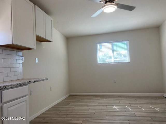 kitchen featuring ceiling fan, decorative backsplash, and white cabinets