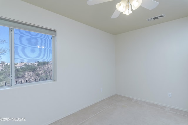 spare room featuring ceiling fan and light carpet