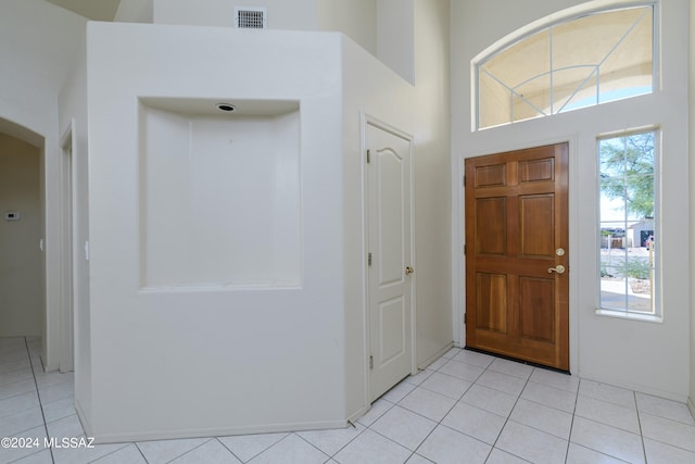 entryway featuring light tile patterned floors and a high ceiling