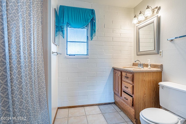 bathroom featuring toilet, a shower with curtain, vanity, brick wall, and tile patterned flooring