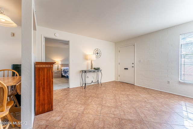 foyer featuring brick wall