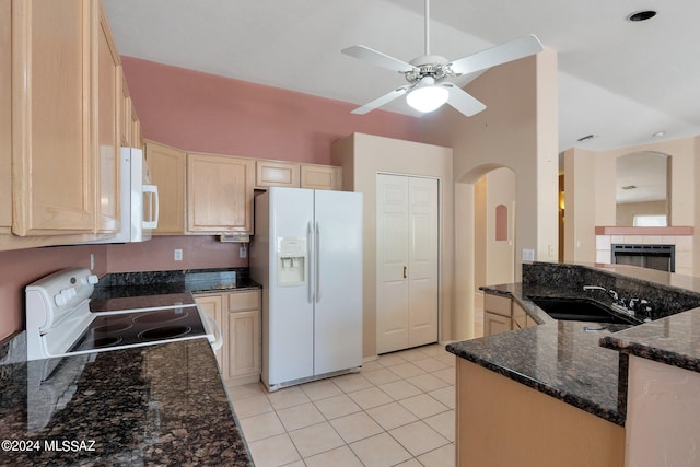 kitchen featuring light tile patterned flooring, light brown cabinets, sink, dark stone countertops, and white appliances