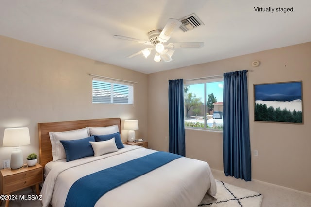 bedroom featuring multiple windows, light carpet, and ceiling fan