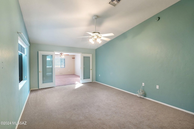 carpeted spare room with ceiling fan and french doors