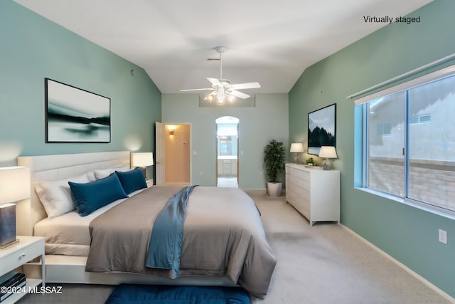 carpeted bedroom with lofted ceiling, ceiling fan, and ensuite bathroom