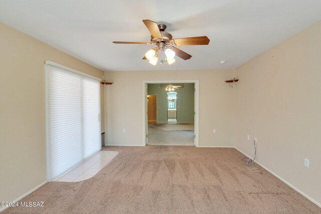 carpeted spare room with ceiling fan