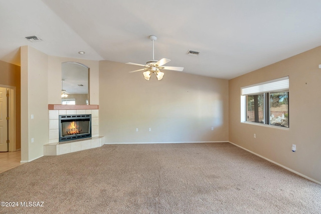 unfurnished living room featuring ceiling fan, a tile fireplace, and carpet