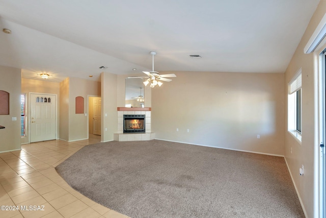 unfurnished living room featuring vaulted ceiling, light colored carpet, ceiling fan, and a fireplace