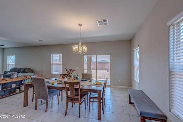 tiled dining area featuring a chandelier