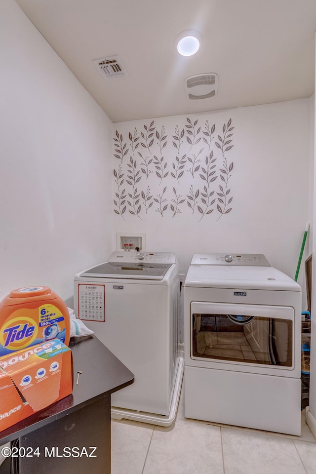 laundry room featuring light tile patterned flooring and washer and clothes dryer