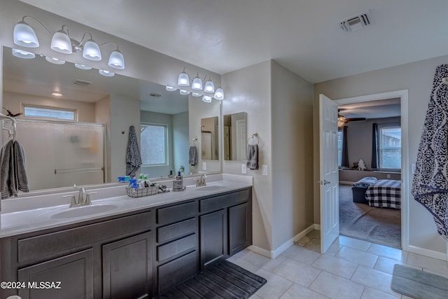 bathroom featuring dual bowl vanity, tile patterned floors, and a healthy amount of sunlight