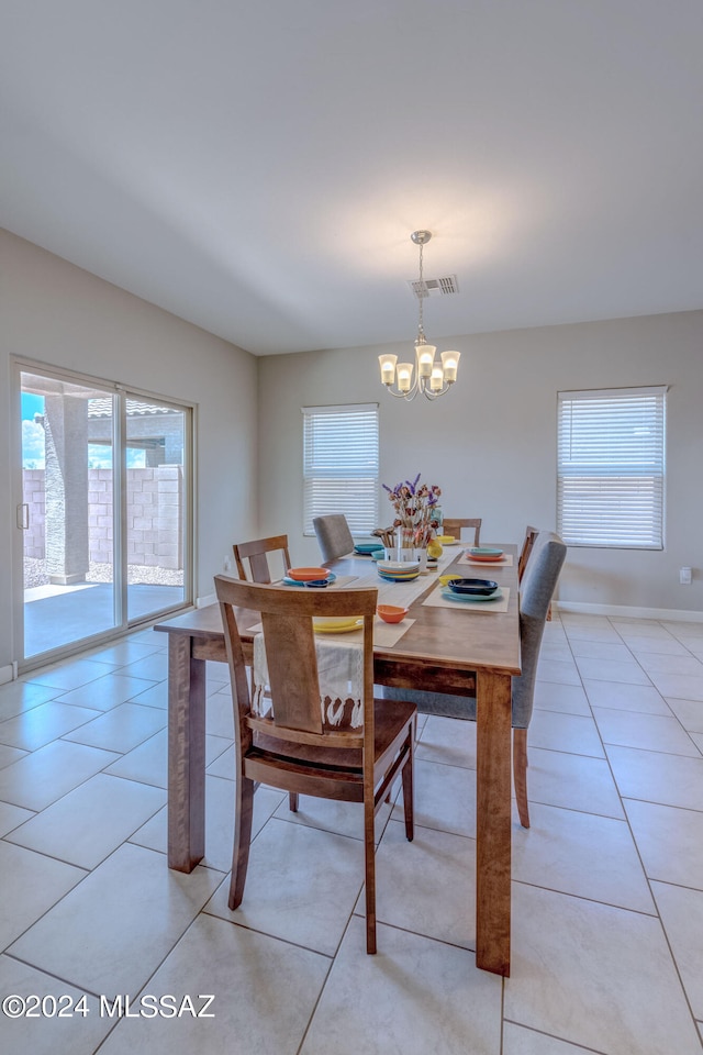 dining area with light tile patterned floors, plenty of natural light, and a chandelier