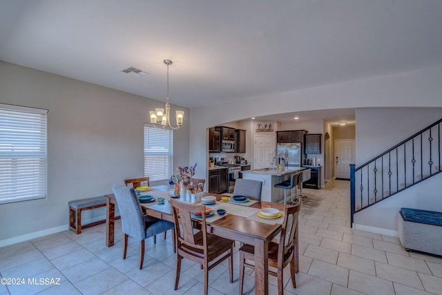 dining room with light tile patterned flooring and a chandelier