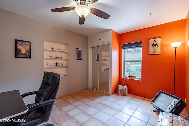 office featuring built in shelves and ceiling fan