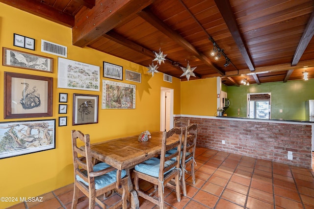 dining room with rail lighting, light tile patterned floors, wooden ceiling, and beam ceiling