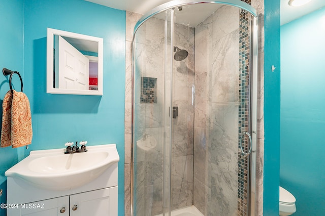 bathroom featuring an enclosed shower, vanity, and toilet