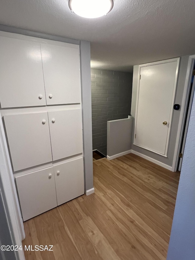 unfurnished bedroom featuring a closet, light hardwood / wood-style floors, and a textured ceiling