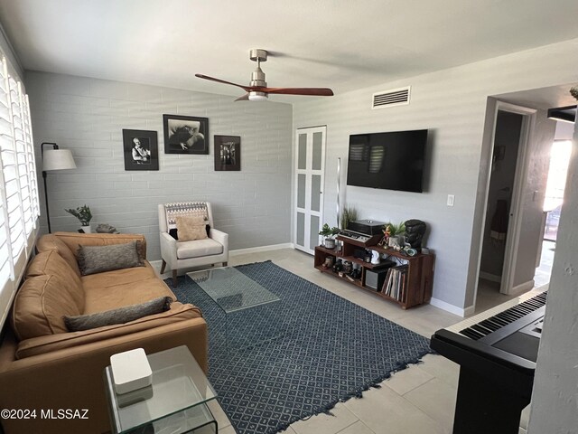 living room with plenty of natural light, brick wall, and ceiling fan