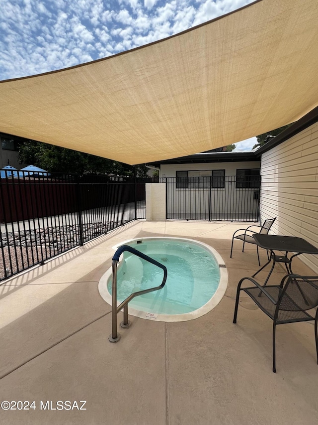 view of pool with a community hot tub and a patio area