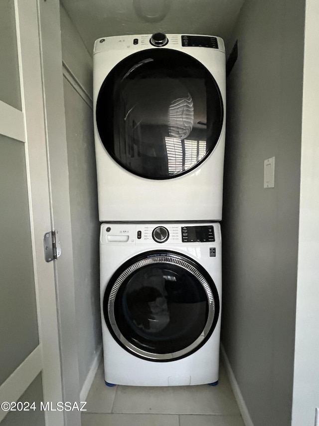 washroom with stacked washer / dryer and light tile patterned floors