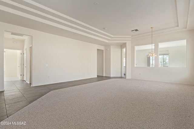 carpeted spare room featuring a chandelier and a raised ceiling