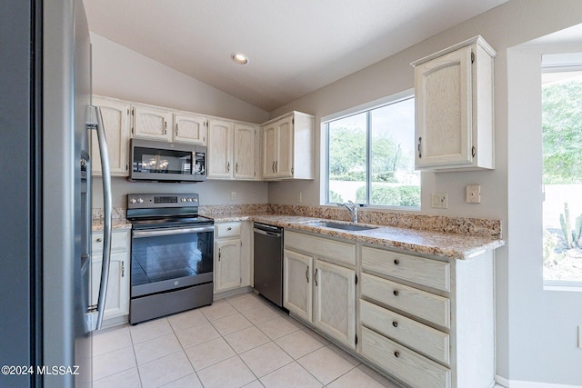 kitchen featuring stainless steel appliances, vaulted ceiling, plenty of natural light, and sink