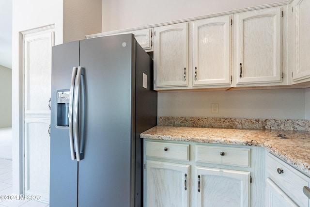 kitchen featuring stainless steel fridge and light stone countertops